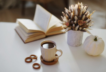 Autumn still life. Coffee cup, flowers, book and pumpkin. Hygge lifestyle, cozy autumn mood. Flat lay, Happy thanksgiving 