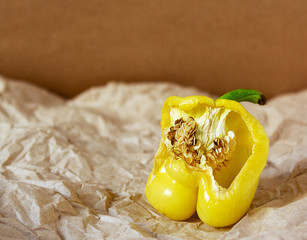Ugly organic green pepper. A deformed half bell pepper with an old rotten core with a damaged, wrinkled flaccid rind on a crumpled brown Kraft crumpled paper background. Organic waste 