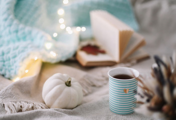 Autumn still life. A cup, dried leaves, book and pumpkin. Hygge lifestyle, cozy autumn mood. Flat lay, thanksgiving background