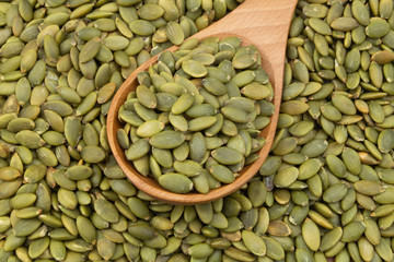 Pumpkin seeds and wooden spoon, top view