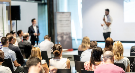 Business and entrepreneurship symposium. Speaker giving a talk at business meeting. Audience in...
