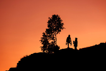Fototapeta premium silhouettes two people on sorrow the young man and girl