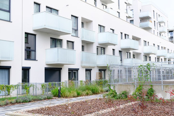 Sidewalk in a cozy courtyard of modern apartment buildings condo with white walls.