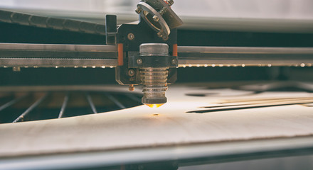 Laser cutting machine is cutting the wooden plank
