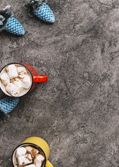 Mugs with marshmallows near blue Christmas toys