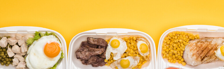 panoramic shot of eco packages with vegetables, meat, fried eggs isolated on yellow