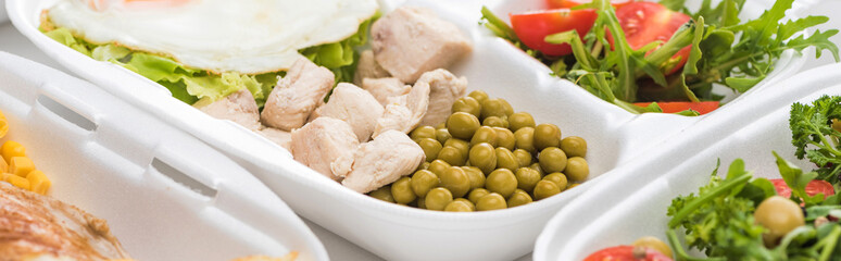 panoramic shot of eco package with green peas, meat and salad on white background