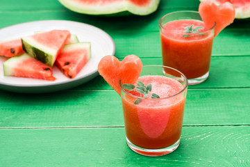 Fresh watermelon blended drink with mint leaves and a heart of watermelon in glasses on a wooden...