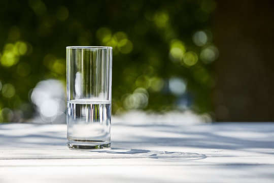 Fresh Clean Water In Transparent Glass At Sunny Day Outside On Wooden Table