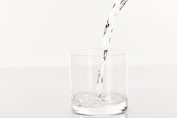 clear fresh water pouring into glass isolated on white