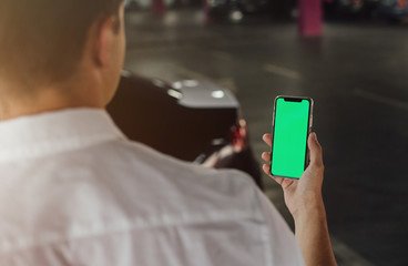 Man using smart phone on parking lot