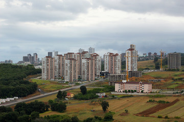 Obraz premium Photo of a combination of nature and residential town with tower building in the beautiful city of Samson in Turkey with cloudy sky