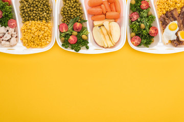 top view of eco packages with apples, vegetables, meat, fried eggs and salads isolated on yellow