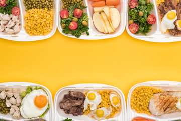 top view of eco packages with apples, vegetables, meat, fried eggs and salads isolated on yellow