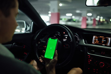 Naklejka premium Man driving holding smartphone in car