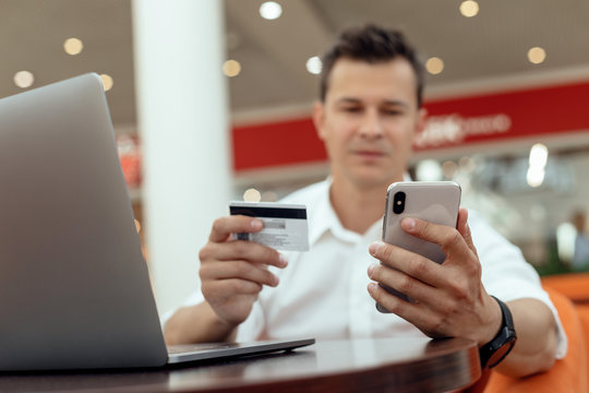 Man using smartphone and laptop computer for online shopping . Credit card