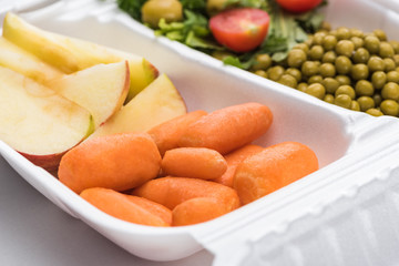 selective focus of eco package with vegetables, apples and salad on white background