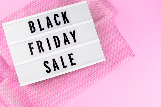 Flat lay design of Black Friday Sale text lightbox on pink background with copy space. Top view. Concept of online shopping and advertising for seasonal offer promotion.