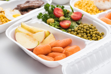 selective focus of eco package with apples, vegetables and salad on white background