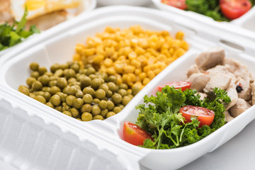 selective focus of eco package with vegetables, meat and salads on white background