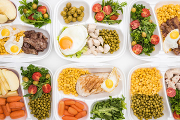 top view of eco packages with apples, vegetables, meat, fried eggs and salads on white background