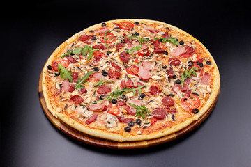 Fresh pizza Campania on wooden cutting board. isolated on dark background.
