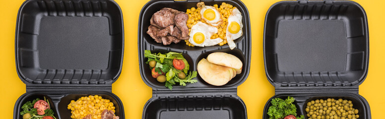 panoramic shot of eco packages with vegetables, apples, meat, fried eggs and salads isolated on yellow