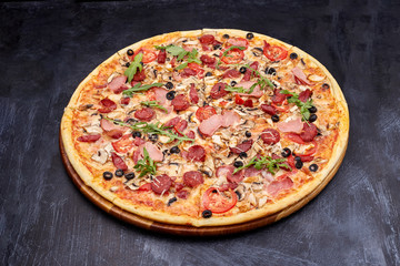 Fresh pizza Campania on wooden cutting board. isolated on dark background.