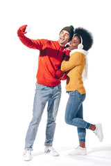 Obraz premium beautiful interracial couple taking selfie on smartphone, isolated on white
