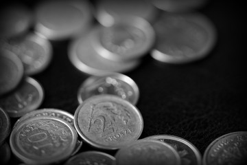 Polish coins scattered on a dark background close up, black and white