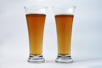 Two glasses of beer on a white background
