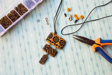 Assembly of ethnic pendant of polymer clay. Handamde jewelry.
