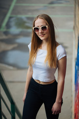 very cute young girl posing as top models on a street in Europe on vacation,actively posing on a sunny summer day,very happy and joyful 