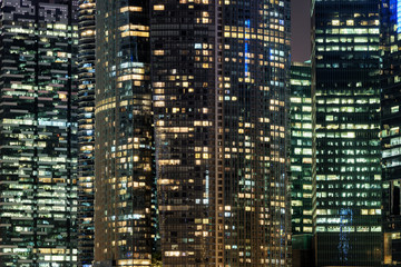 Fototapeta na wymiar Glowing windows of skyscrapers at evening. Night cityscape
