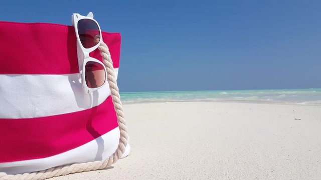 Summer Accessories bag on a beach in Thailand, with sunglasses hanging out