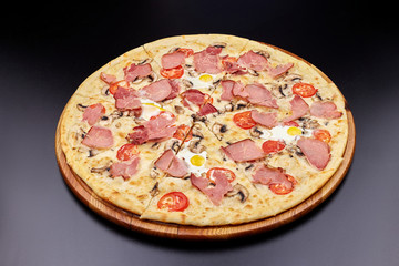 Carbonara pizza with bacon and egg on beautiful grey table. Isolated on dark background.