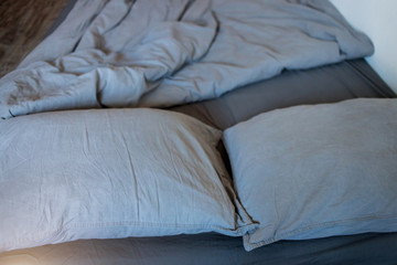 Obraz premium Blue bed sheets and pillows after night's sleep.
