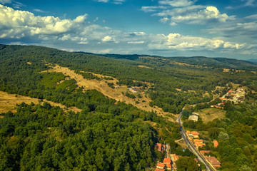 Panoramic Drone Aerial View view of mountain peaks. Hilltops covered with forest. Green nature background aerial view mountain landscape.