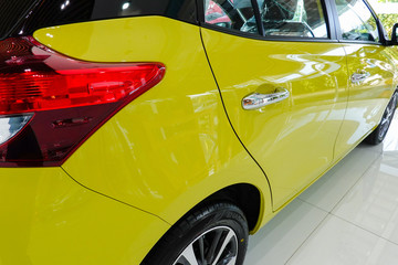 Yellow modern new car in showroom.