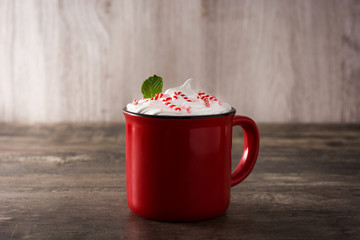 Peppermint coffee mocha decorated with candy canes for Christmas on wooden table.
