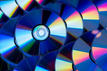 Many musical compact discs with a rainbow spectrum of colors as a bright background