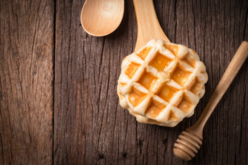 waffle on wooden spoon and wood plate