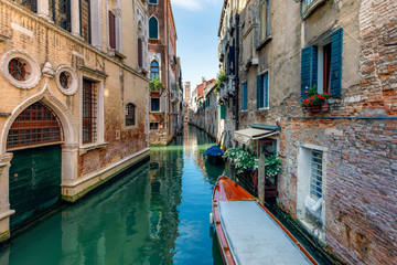 Fototapeta na wymiar Narrow water canals in Venice, with small boats docked near the houses, Venice, Italy