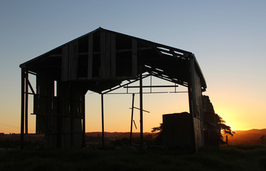 Old tin milking shed at sunset