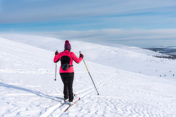 Fototapeta na wymiar Woman cross country skiing in Lapland Finland