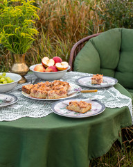 Ciasto jabłecznik na stole pośrodku łąki - obrazy, fototapety, plakaty