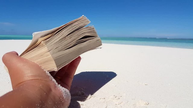 a person fell asleep while reading a book on the beach