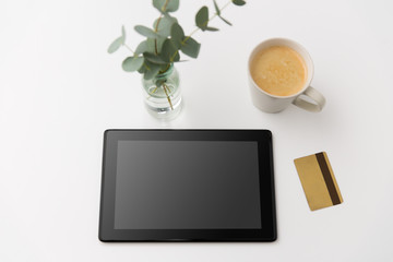online shopping, sale and technology concept - tablet pc computer, credit card and cup of coffee on white background