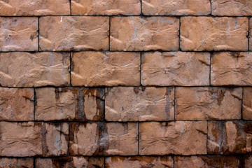 Brick wall of large bricks dark brown.