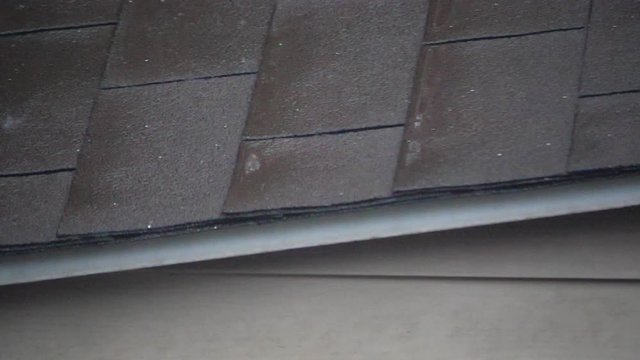 Rain falling in slow motion on the roof of a typical NorthAmerican house made with tiles.